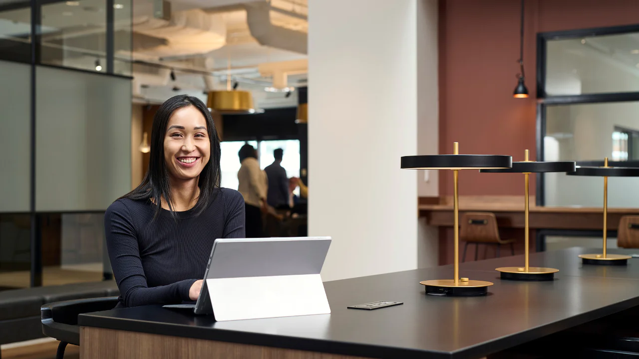 ATCO employee smiling at computer